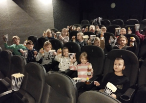 Dzieci w kinie z popcornem i soczkami.
