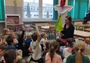 Nauczyciel prezentuje Marzannę grupie dzieci.