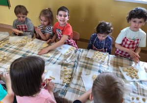 Dzieci formują z ciasta ślimaczki.