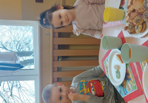 Chłopiec i dziewczynka uśmiechają się do zdjęcia jedząc cukierki