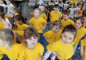 Dzieci w żółtych koszulkach rozgrzewają się przed olimpiadą.