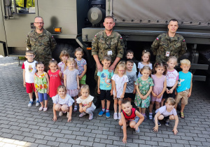 Grupowe zdjęcie żołnierzy i dzieci.