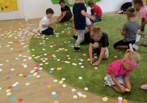 Dzieci zbierają kropki z podłogi.
