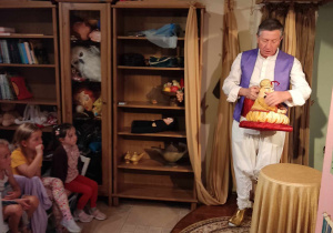 Aktor pokazuje dzieciom lalki.