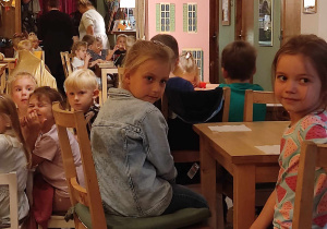Dwie dziewczynki siedzą przy stoliku.