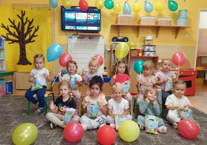 Dziewczynki trzymają upominki i balony