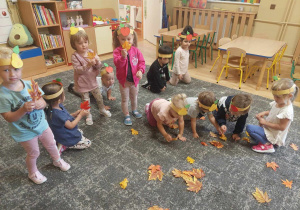 Dzieci zbierają liście na dywanie