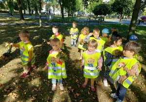 Dzieci stojąc trzymają liście