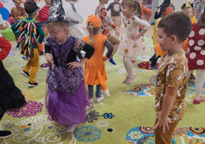 Dzieci w jesiennych strojach wspólnie bawią się podczas balu.