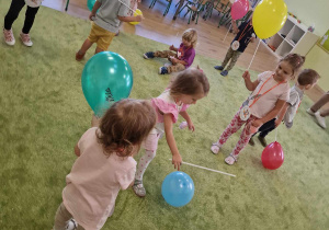 Dzieci stoją w rozsypce z balonami