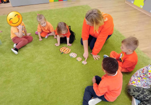 Dzieci siedzą na dywanie