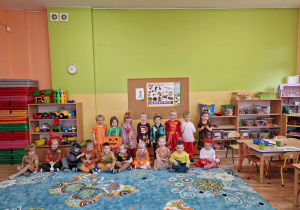 Dzieci przebrane w kolorowe stroje pozują do zdjęcia w swojej sali.