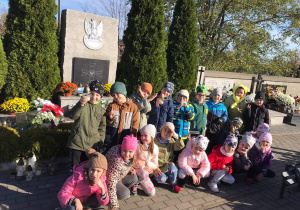 Grupa dzieci pozuje do zdjęcia na cmentarzu przed Grobem Nieznanego Żołnierza.