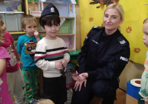 Chłopiec stoi w czapce policjanta