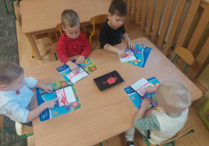 Dzieci wykonują flagę Polski przy stoliku