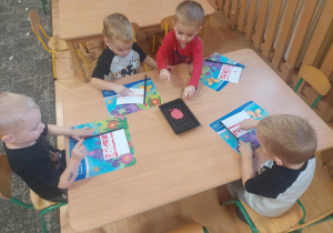 Dzieci wykonują flagę Polski przy stoliku
