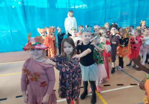 Przebrane dzieci w stroje jesienne tańczą w rytm muzyki.