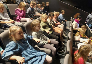 Dzieci siedzą na widowni teatru .
