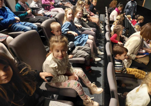 Dzieci siedzą na widowni teatru w oczekiwaniu na spektakl. .