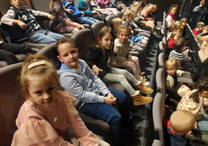 Dzieci siedzą na widowni teatru .