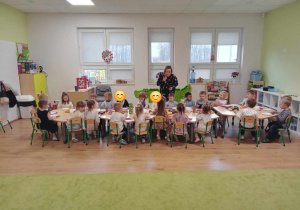 Dzieci siedzą przy stolikach