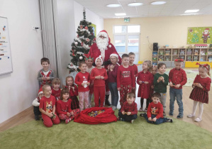 Dzieci pozują do zdjęcia razem ze św. Mikołajem.