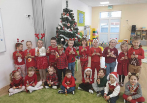 Dzieci pozują do zdjęcia z czekoladowym upominkiem od św. Mikołaja.