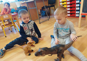 Chłopcy bawią się dinozaurami interaktywnymi