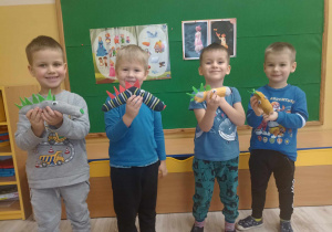 chłopcy prezentują wykonane ze skarpetek smoki