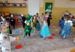 dzieci tańczą wskakując na krążki rozłożone na dywanie