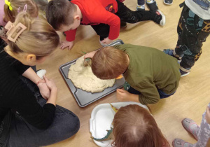 Dzieci wykonują odciski dinozaurów w masie solnej