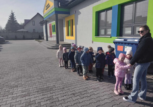 dzieci stoją w parach przed przedszkolem