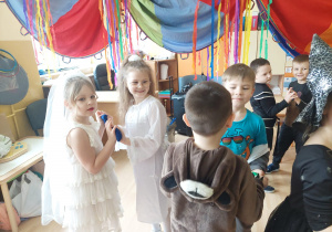 Dziewczynki i chłopcy tańczą w rytm muzyki.