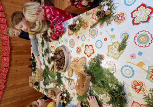 Dzieci wykonują stroiki bożonarodzeniowe z gałązek jodły, szyszek, orzechów