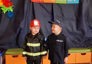 Chłopcy przebrania za policjanta i strażaka pozują do zdjęcia