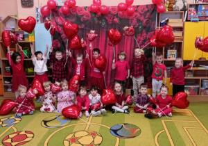 dzieci pozują z balonami w kształcie serca