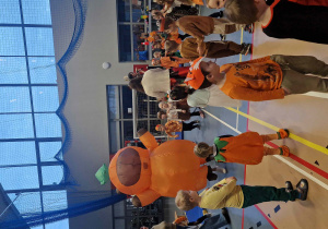 Dzieci tańczą do muzyki, po środku stoi dmuchana maskotka w kształcie kapibary