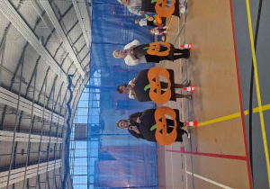 Pracownicy przedszkola trzymają w rękach dynie wycięte z kartonu