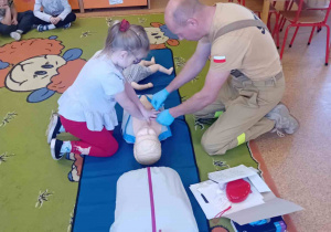 Dziecko ćwiczy na fantomie uciśnięcia klatki piersiowej