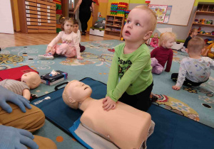 Dziecko ćwiczy na fantomie uciśnięcia klatki piersiowej