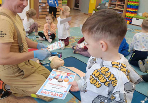Dziecko trzyma w rękach dyplom za udział w warsztatach z pierwszej pomocy