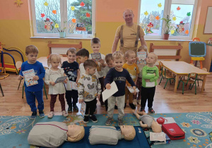 Grupa dzieci pozuje do zdjęcia z strażakiem