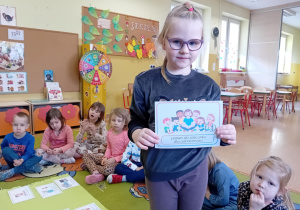dziewczynka trzyma kartkę z napisem "Prawo do szacunku dla samego siebie"