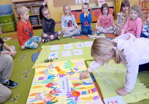 Dzieci tworzą plakat związany z tematyką obchodów dnia praw dziecka