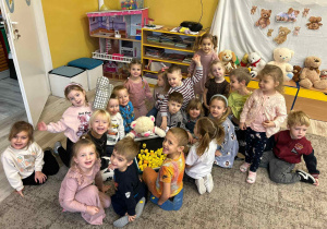 Grupa dzieci siedzi na dywanie