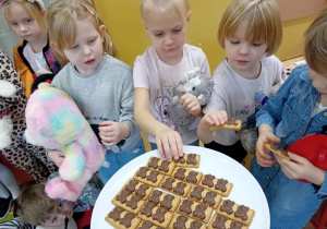 Dzieci częstują się ciasteczkami w kształcie misia.