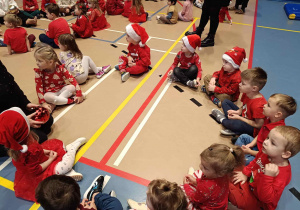 Dzieci siedzą w kołach i przekazują sobie bombkę