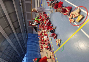 Dzieci siedzą w rzędach, jeden za drugim.