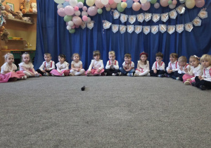 Dzieci siedzą w grupie na dywanie