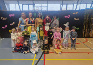 Dzieci pozują do zdjęcia w kolorowych strojach